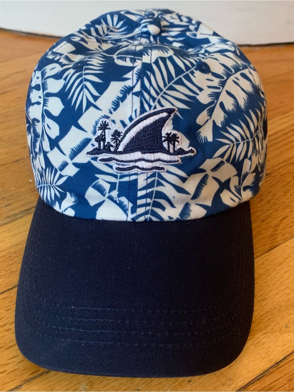 Margaritaville blue and white tropical leaf pattern cap with shark graphic